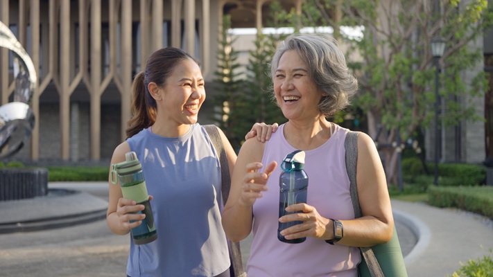 A mother and daughter enjoying a conversation after a workout