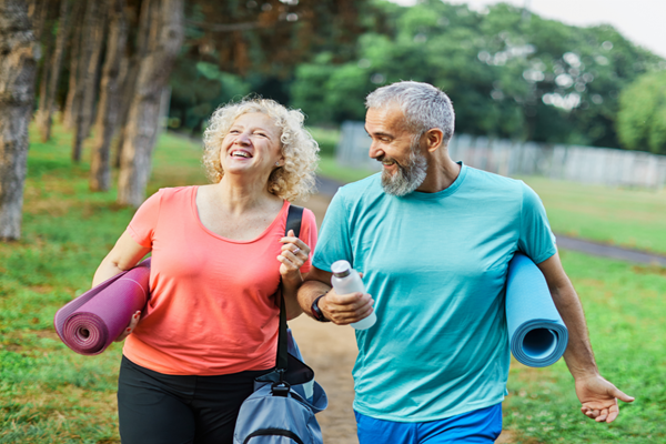 couple carrying their yoga mats outside